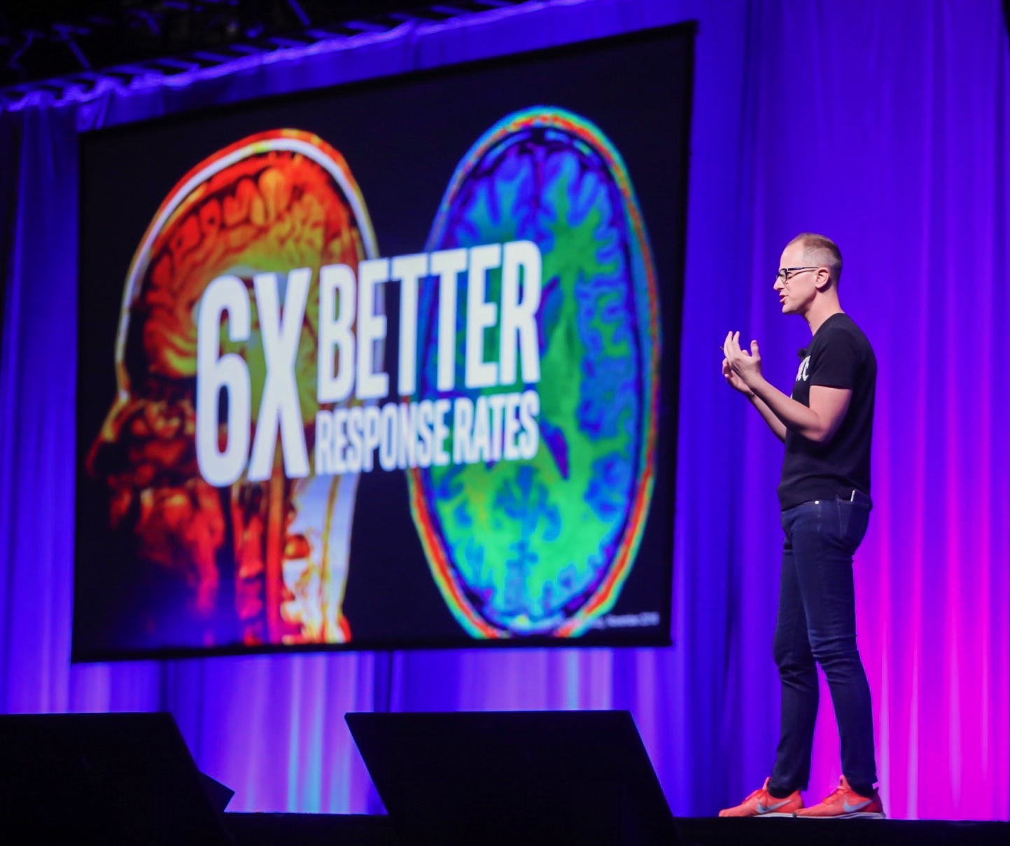 Bryce in SEQUENCE ME shirt on stage with 6X BETTER RESPONSE RATES slide